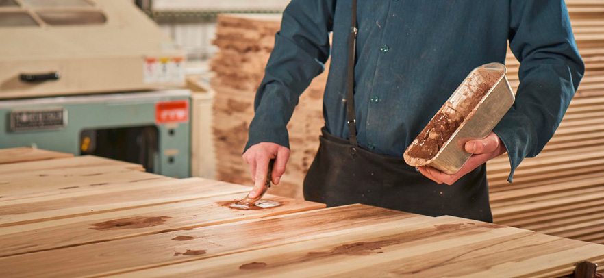 man applying brush to wood